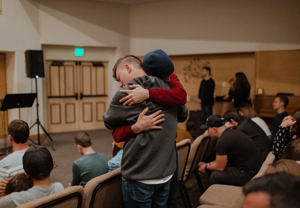 Two men hugging each other in a crowd.